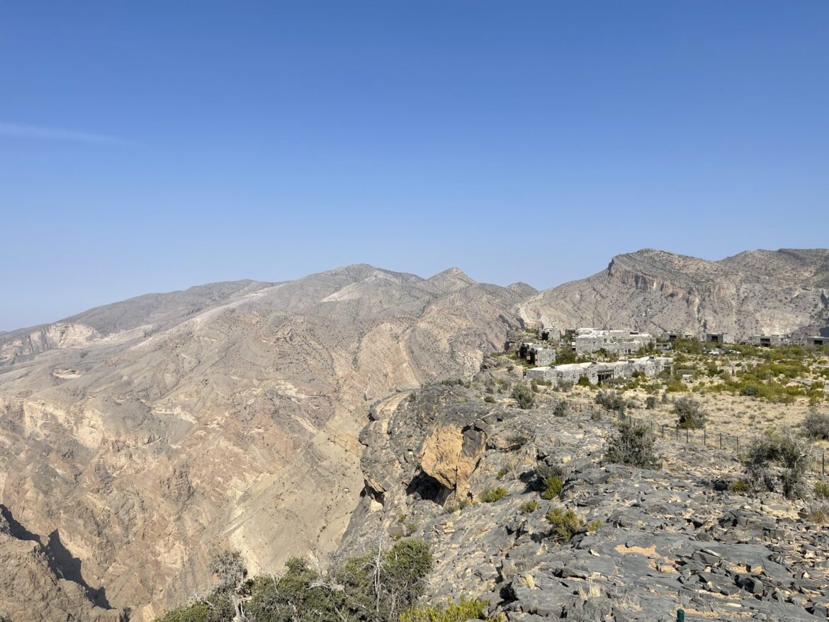 a landscape of mountains and a building