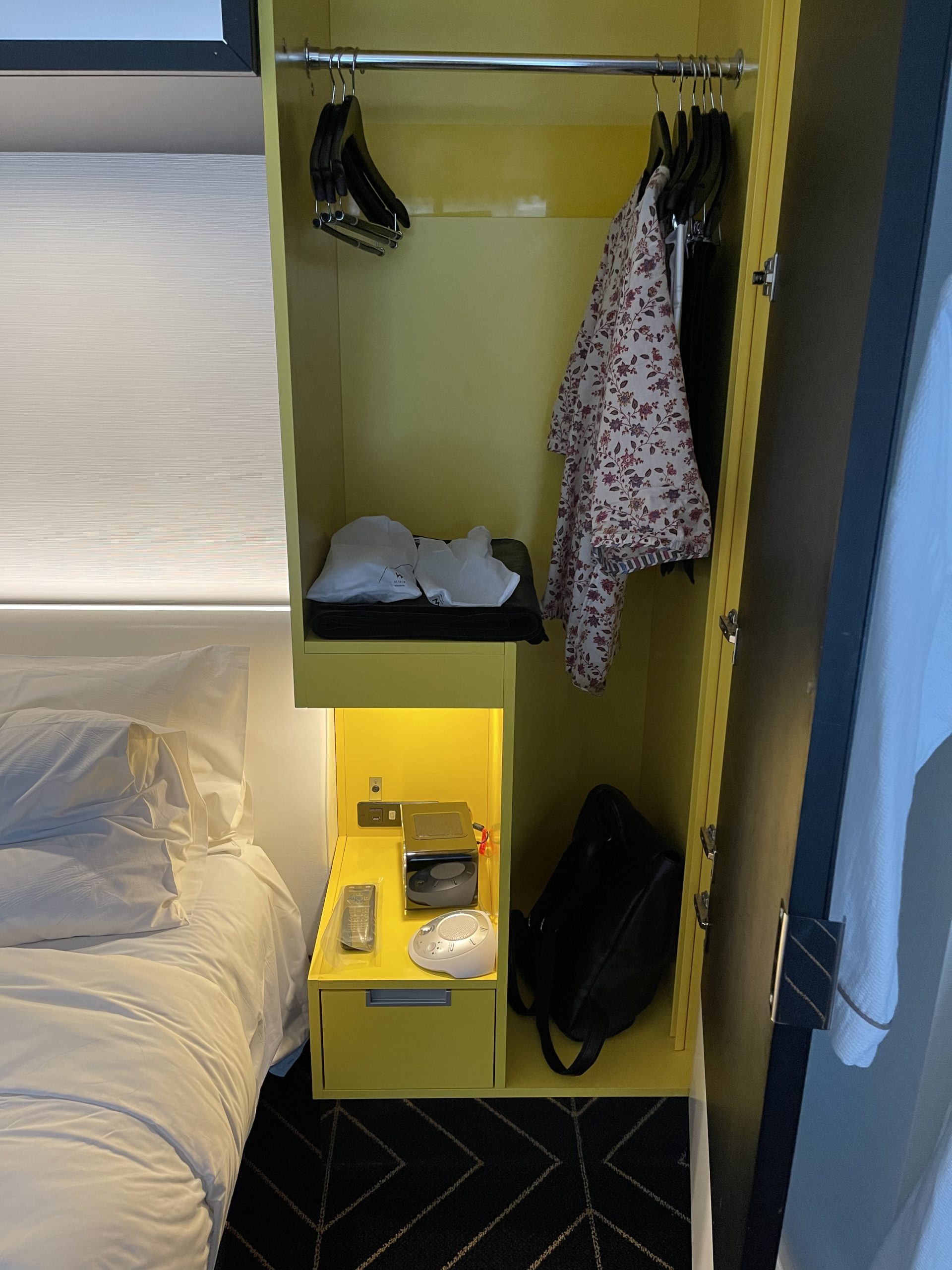 a yellow cabinet with a shelf and a bed