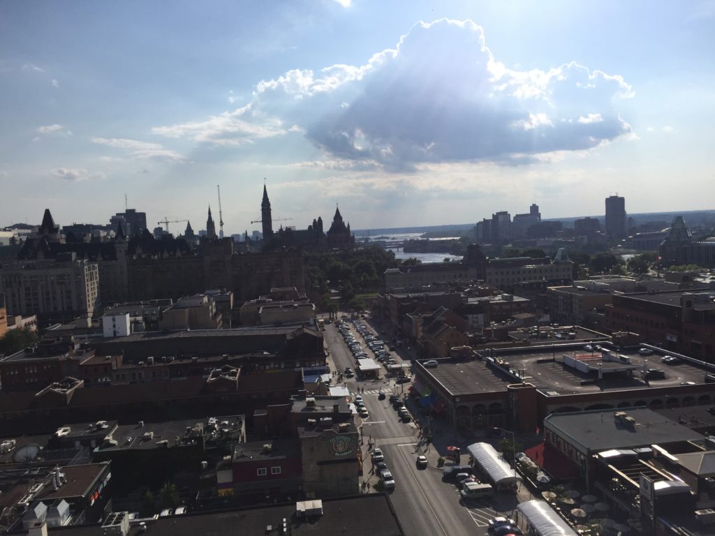 View from rooftop: Byward Market below, Parliament and Ottawa river in the distance