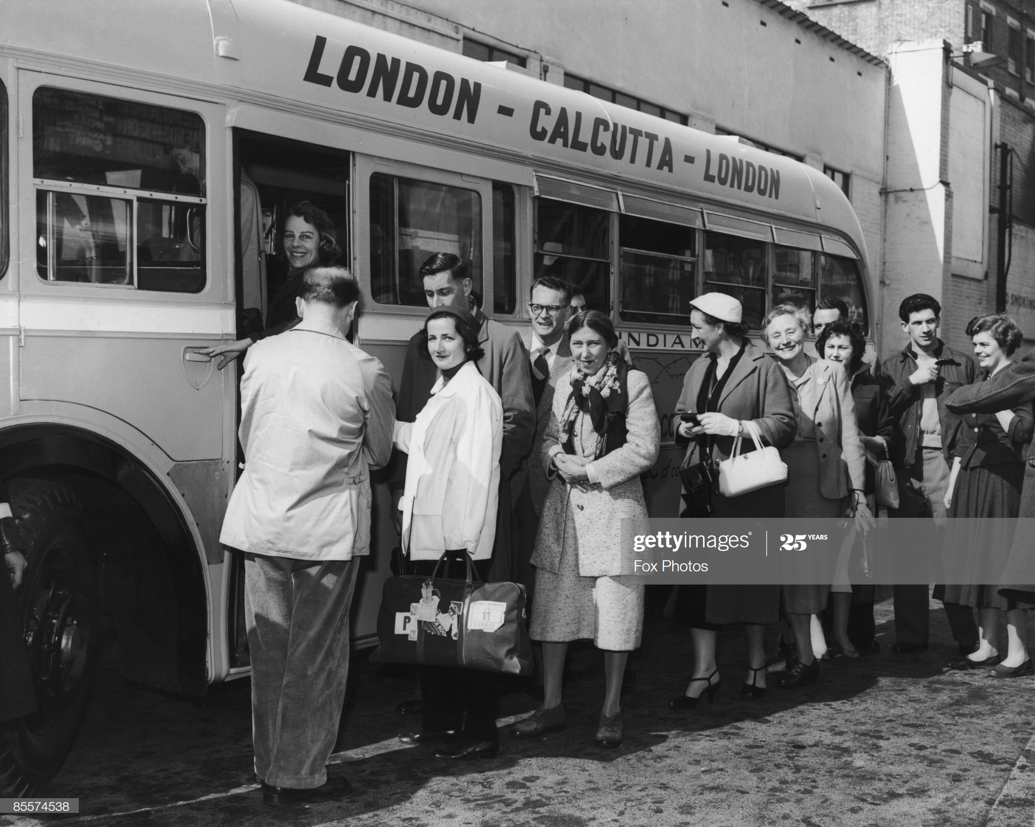 a group of people standing in a line next to a bus