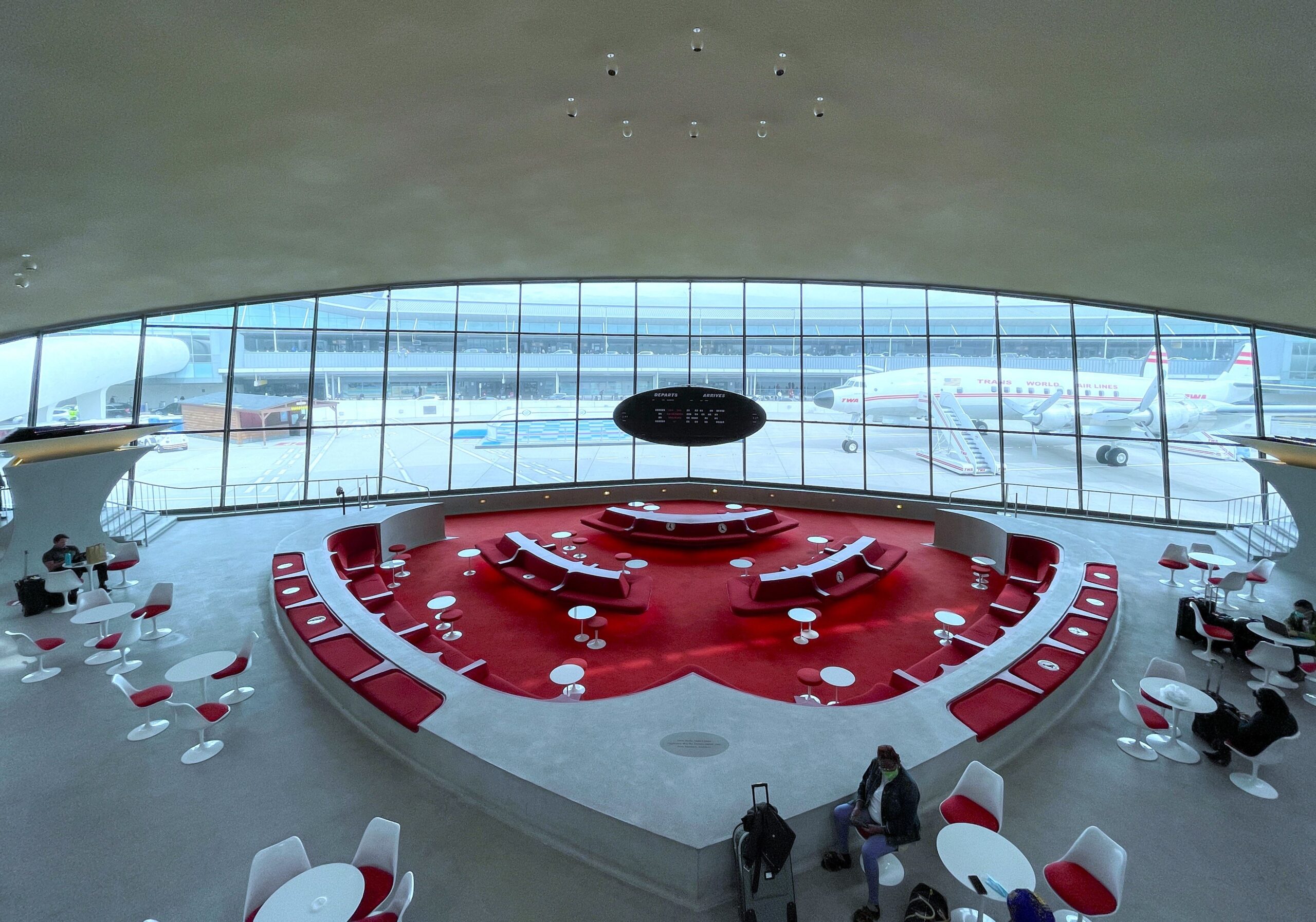 a large circular area with red and white tables and chairs