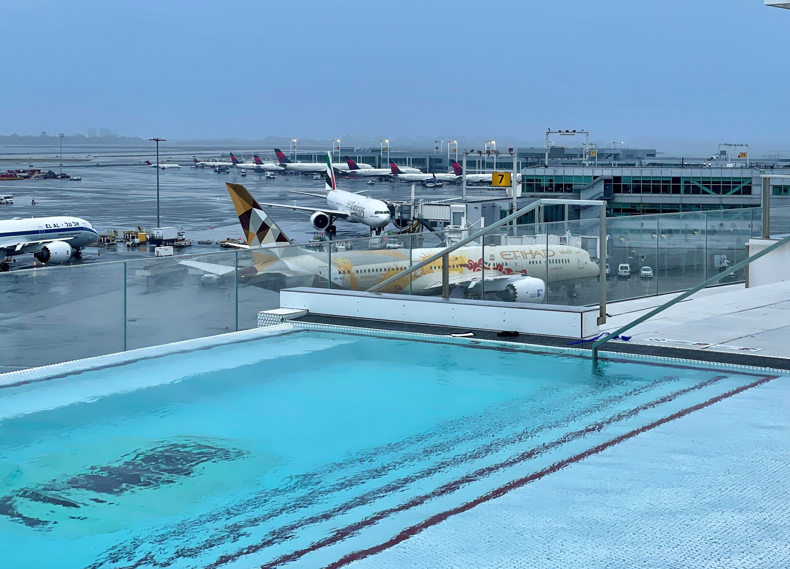 a pool with airplanes in the background
