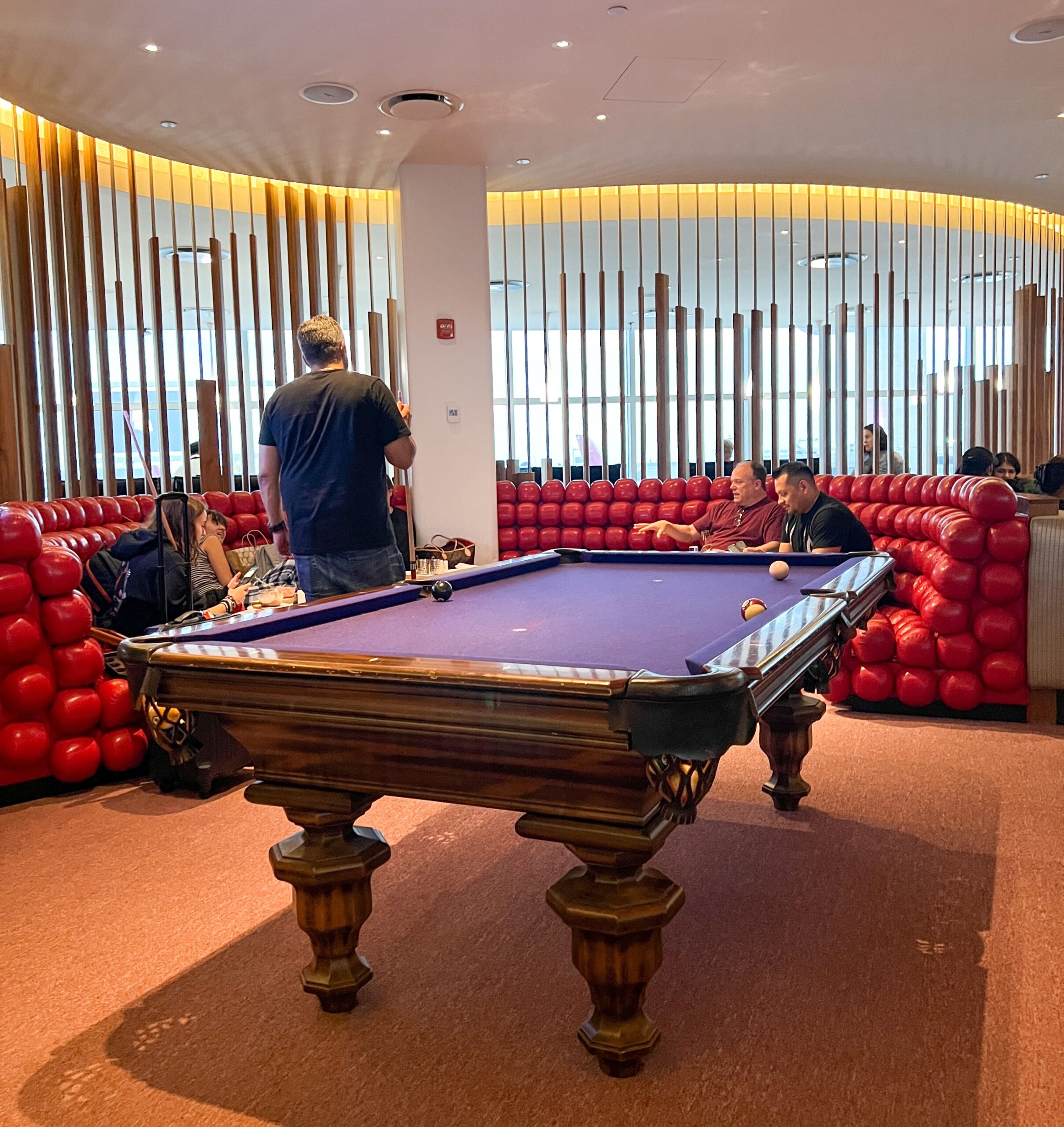 a pool table in a room with red seats