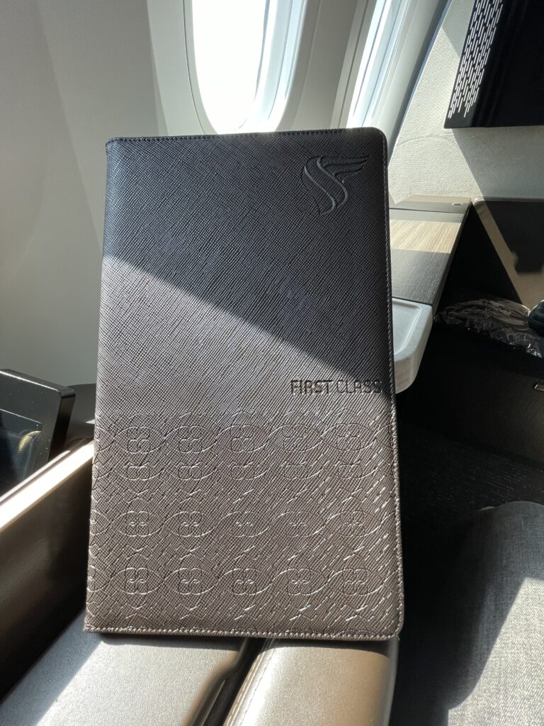 a black leather folder on a plane