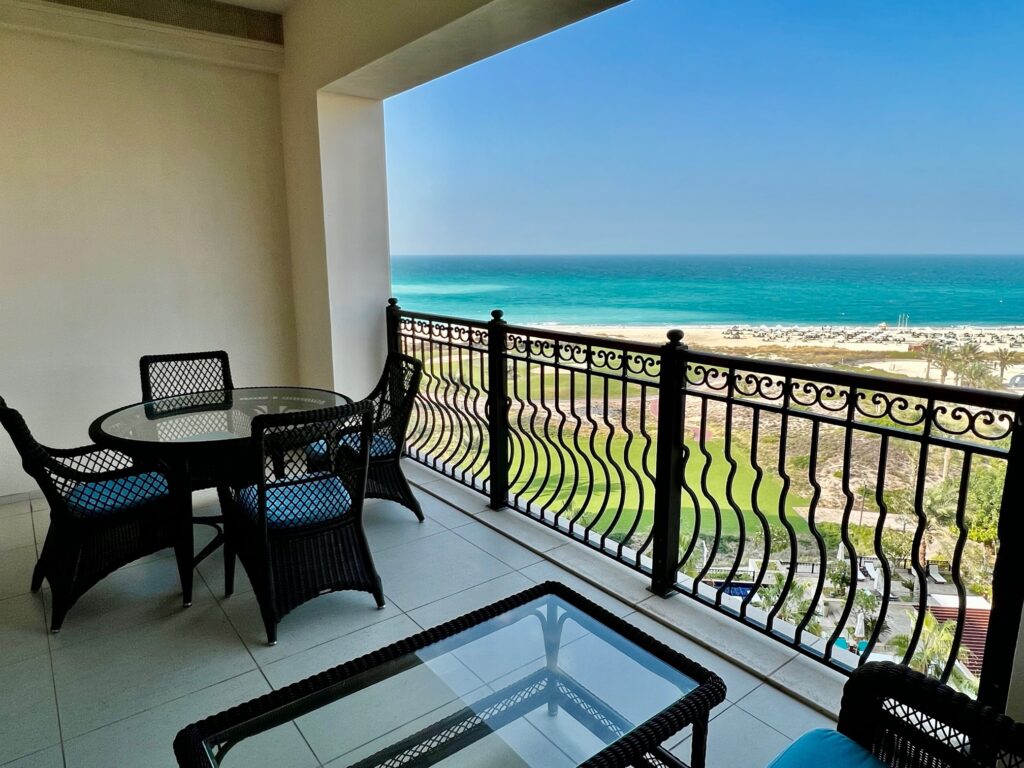 a balcony with a table and chairs overlooking the ocean