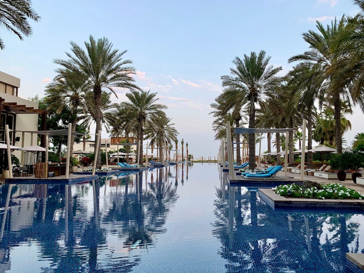 a pool with lounge chairs and palm trees