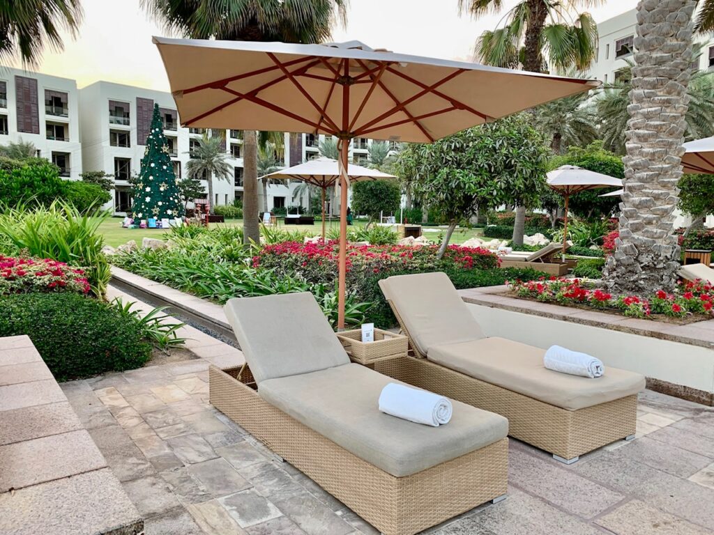 two lounge chairs and umbrellas in a resort