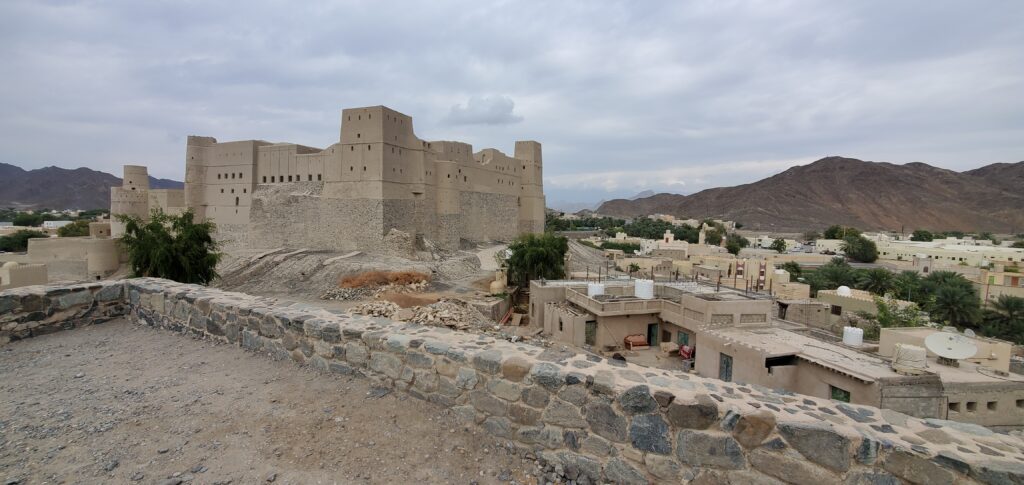 a stone wall with a castle in the middle of a desert