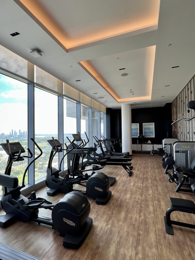 a room with exercise equipment and a large window