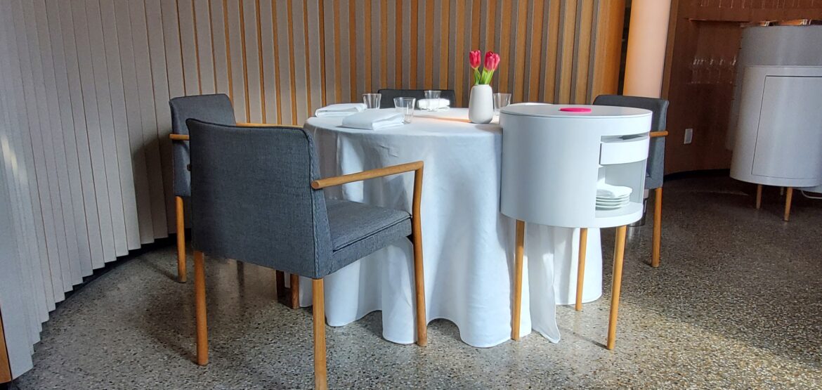 a table with a white tablecloth and chairs