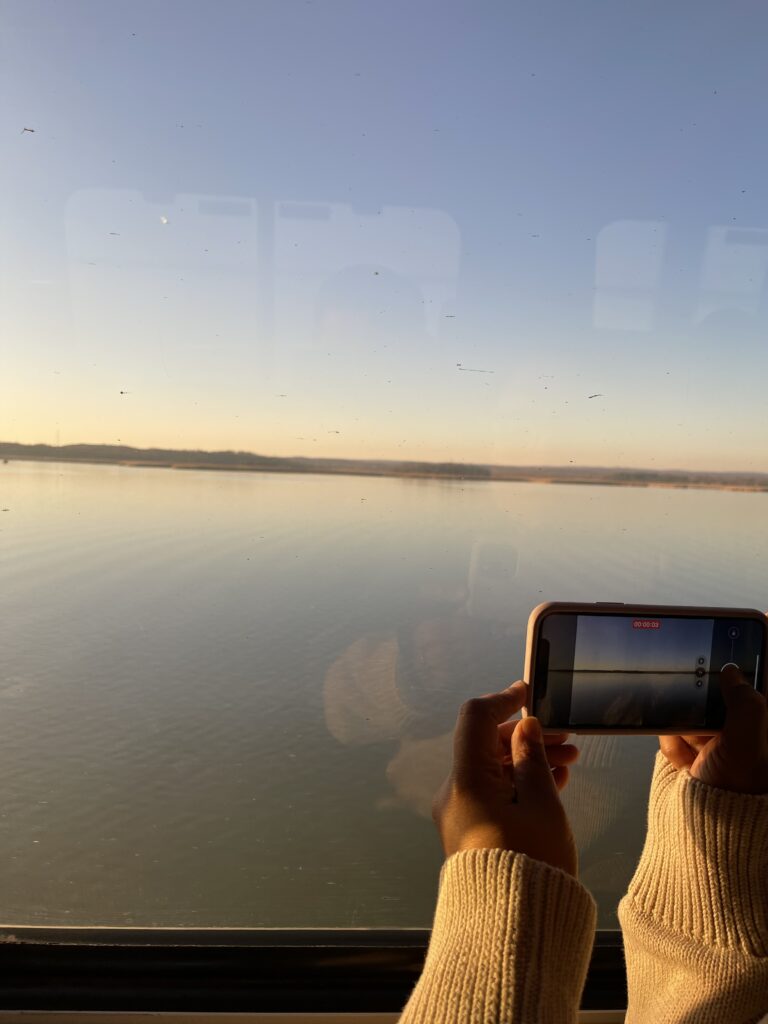 a person holding a phone to a body of water