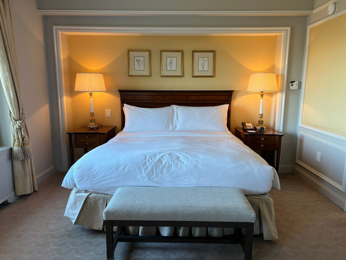 a bed with a bench and lamps