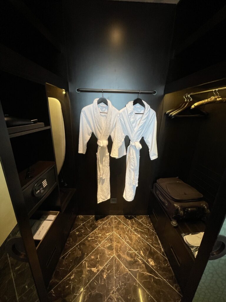a couple white bathrobes from a rail in a room