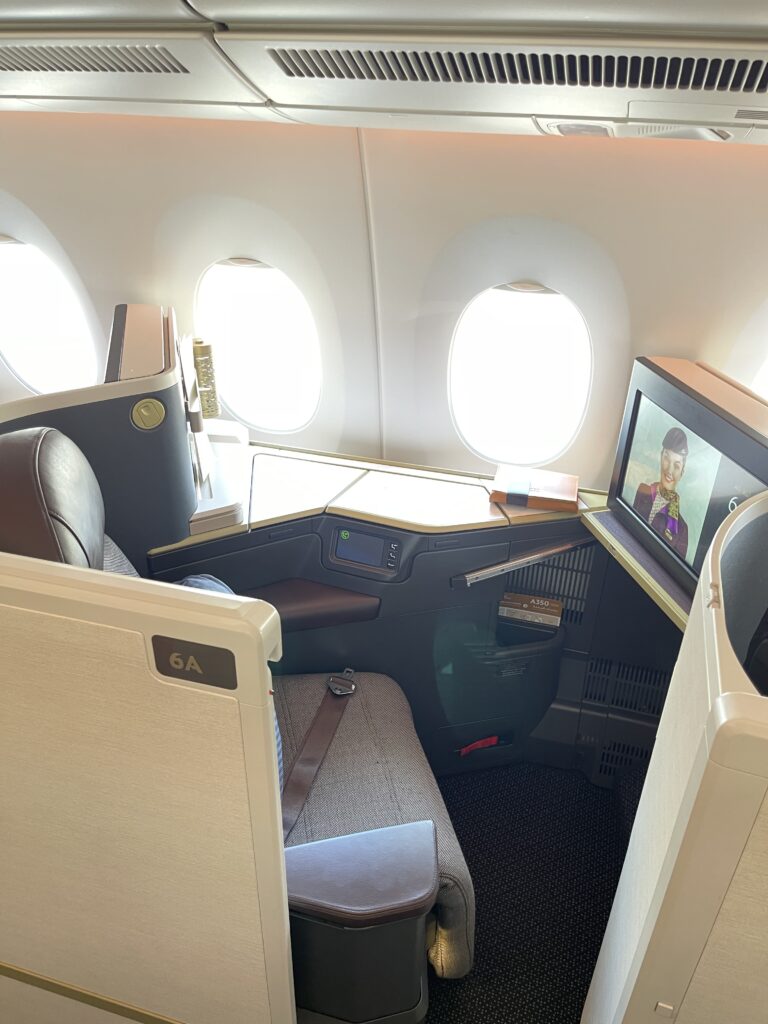 a seat and a television on the back of a plane