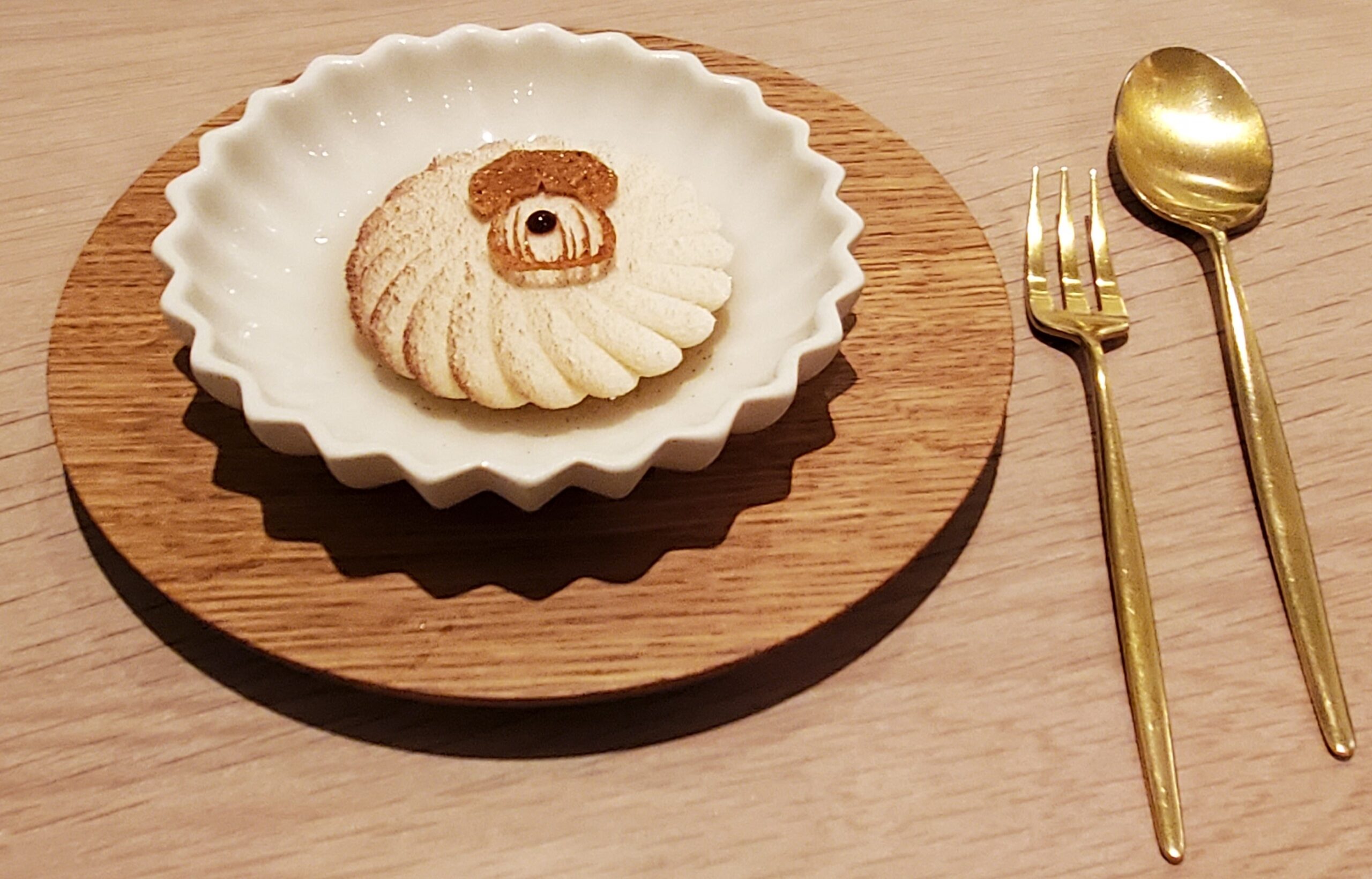 a plate with a cookie on it and a fork on a wood surface