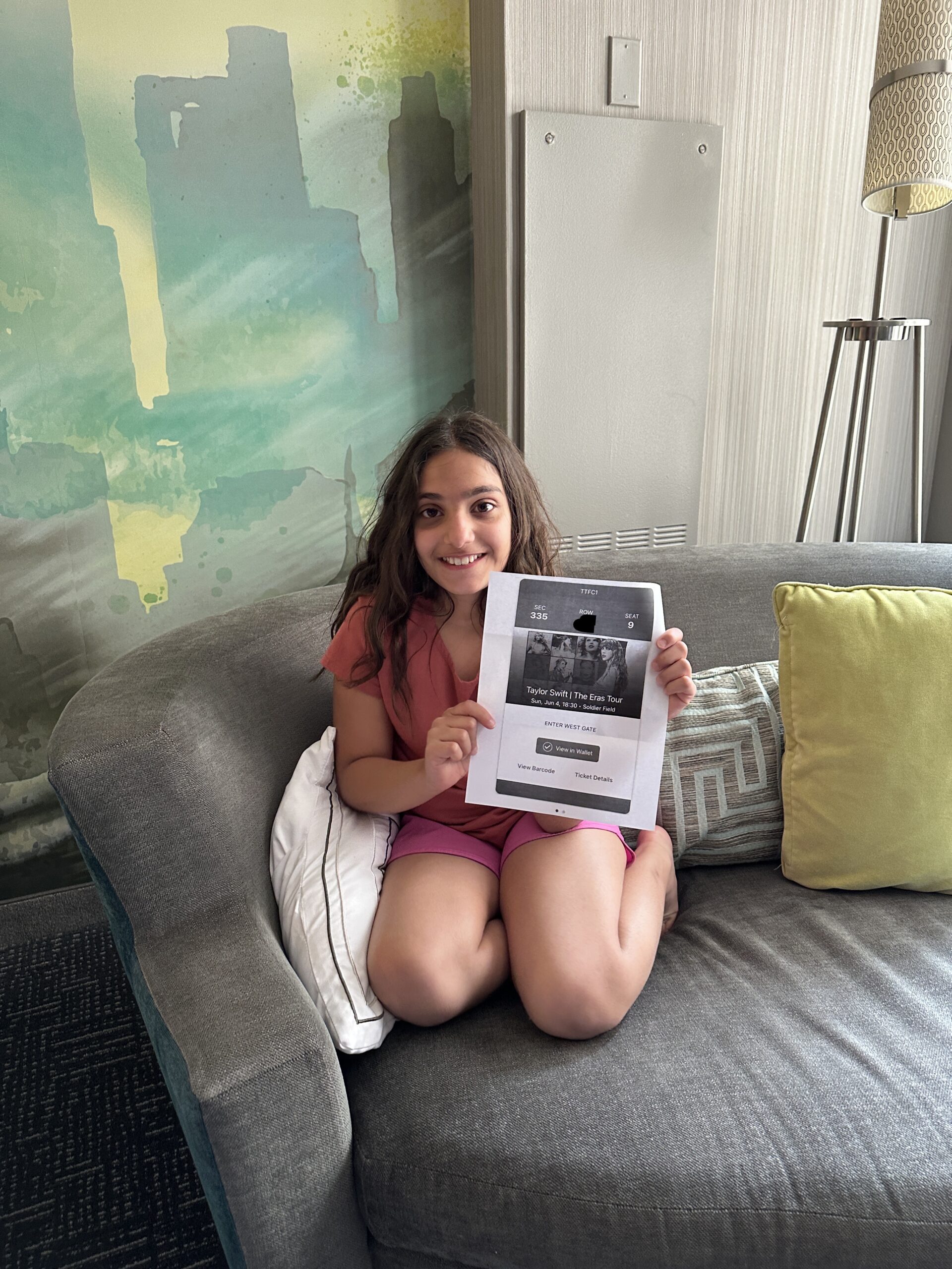 a girl sitting on a couch holding a picture of her