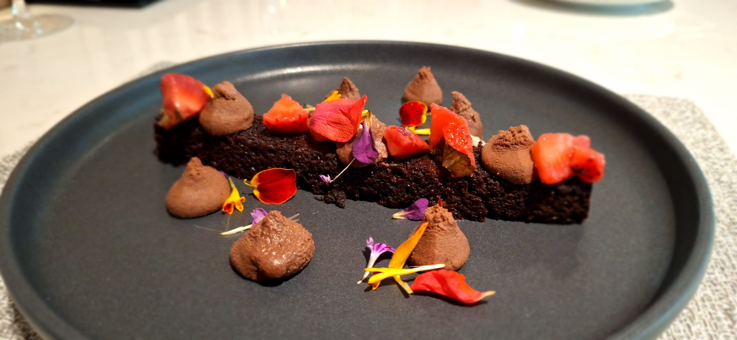 a plate of food with flowers and chocolate frosting