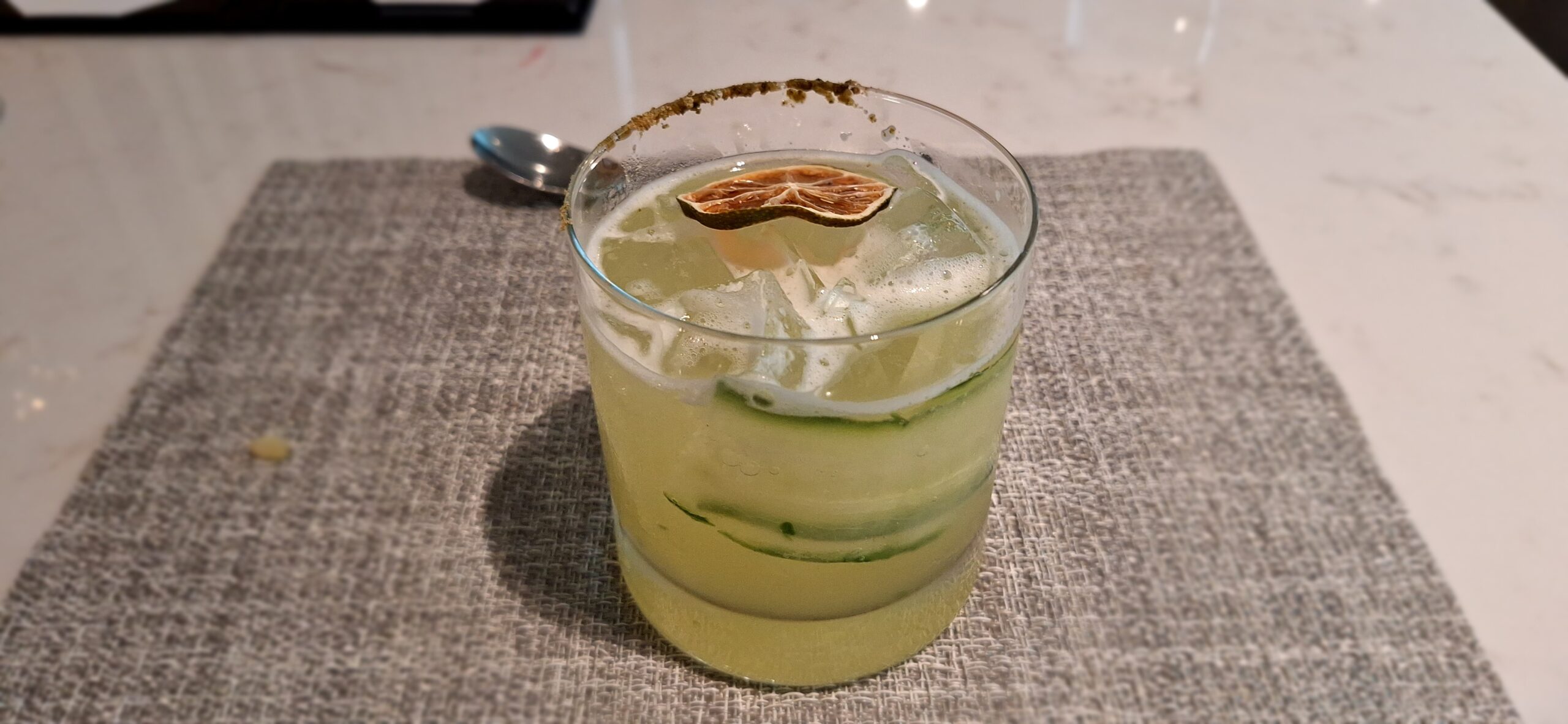 a glass with a drink and a slice of lime on top