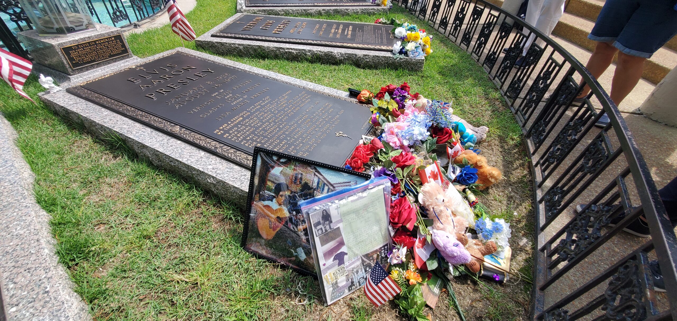 a grave stones with flowers and flags
