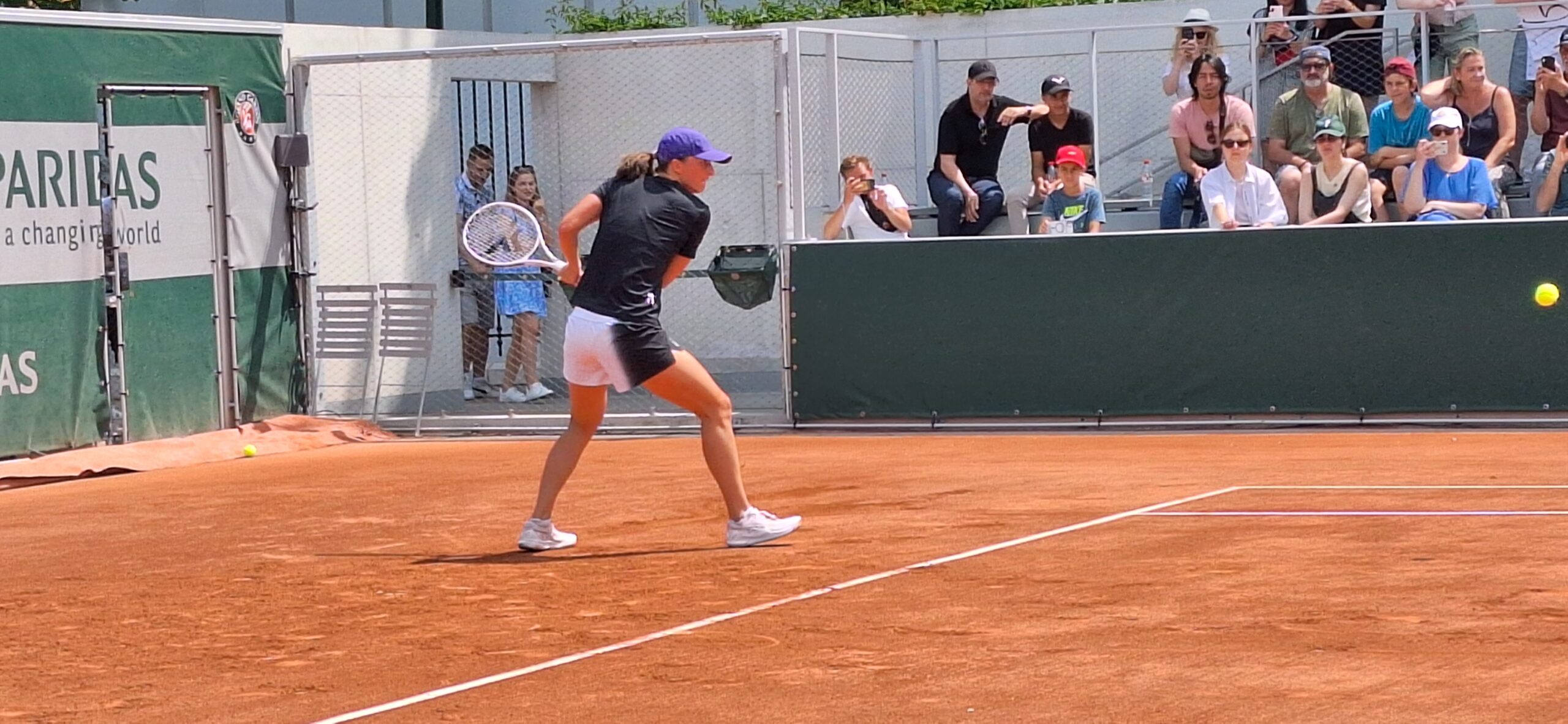 a woman playing tennis on a clay court