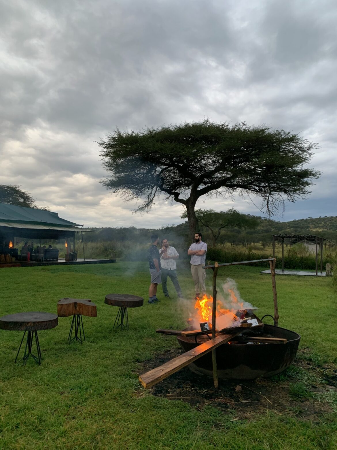 a group of people standing around a fire pit