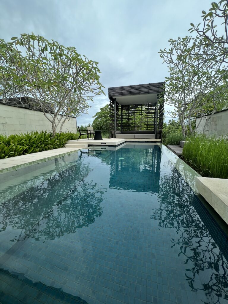 a pool with trees and a pergola