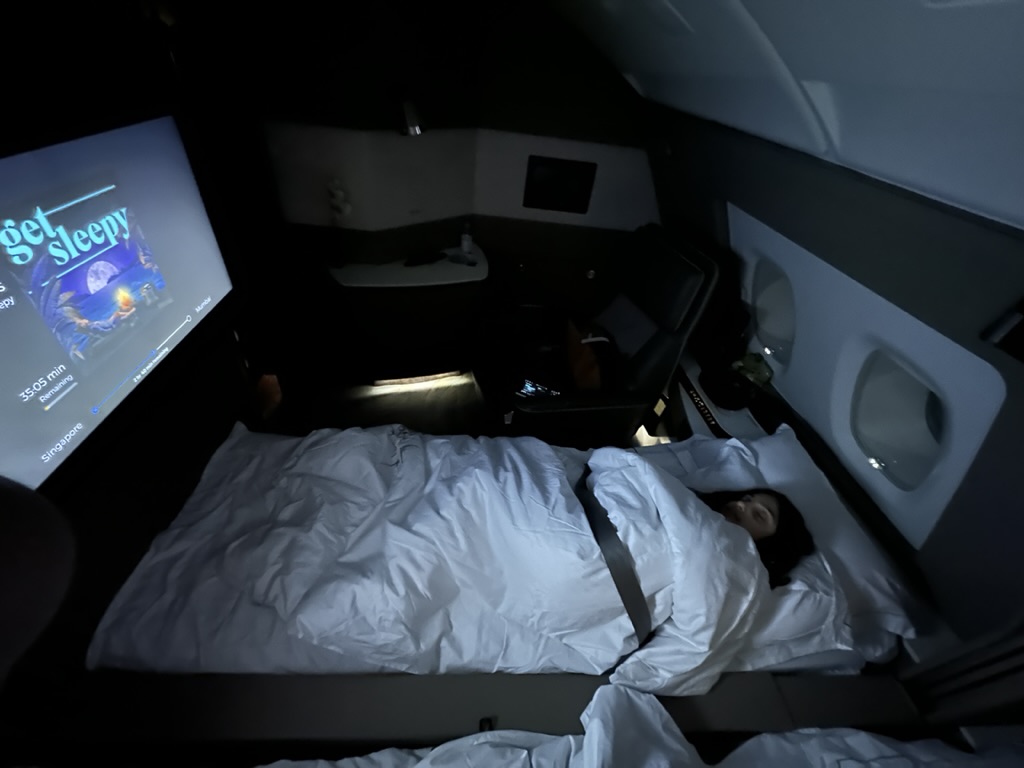 a person lying in a bed with a tv