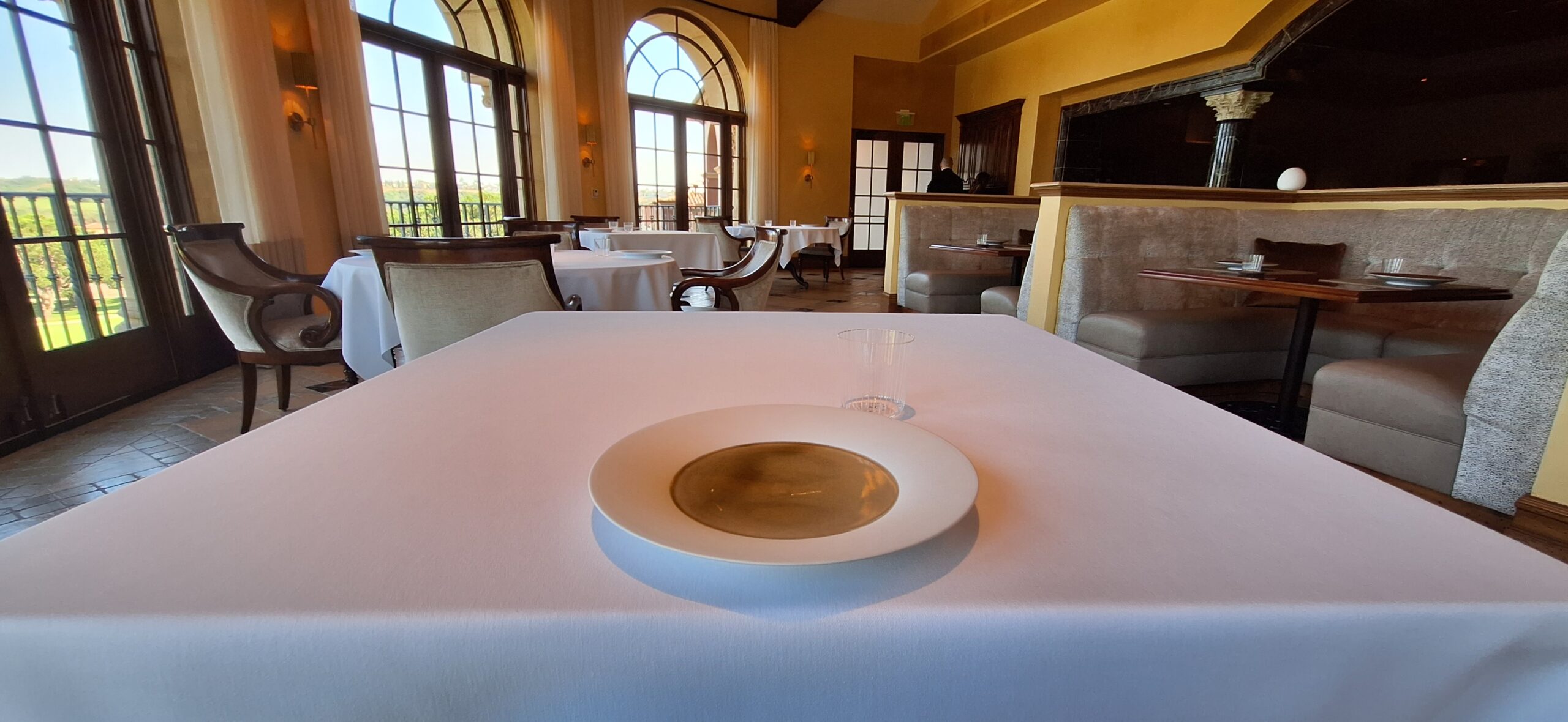 a white plate on a table with a white tablecloth