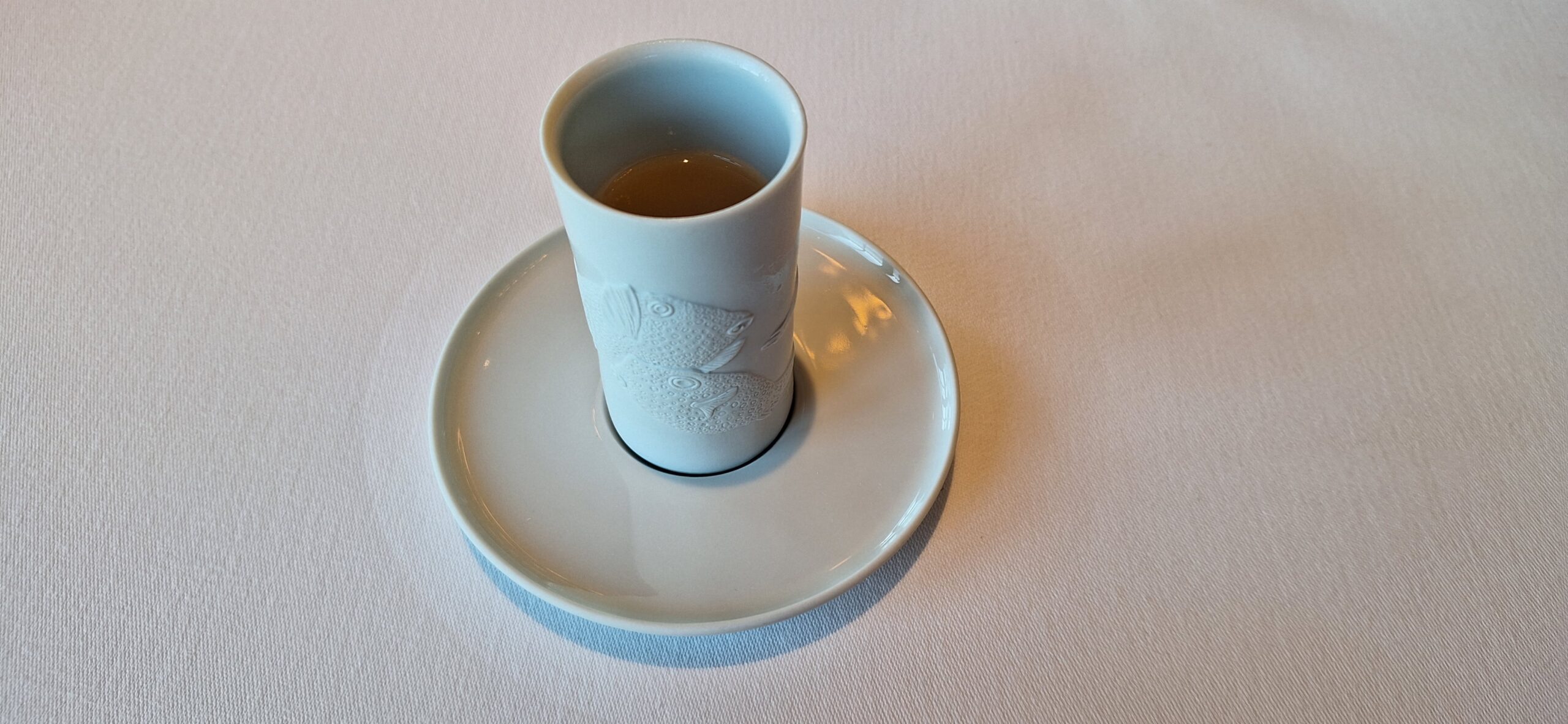a white cup with a fish design on it