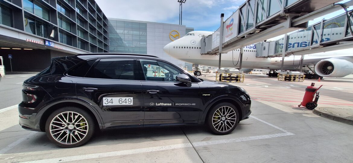 a black car parked next to a plane