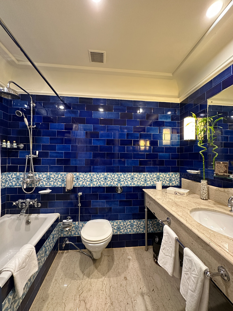 a bathroom with blue tile walls and a sink and toilet