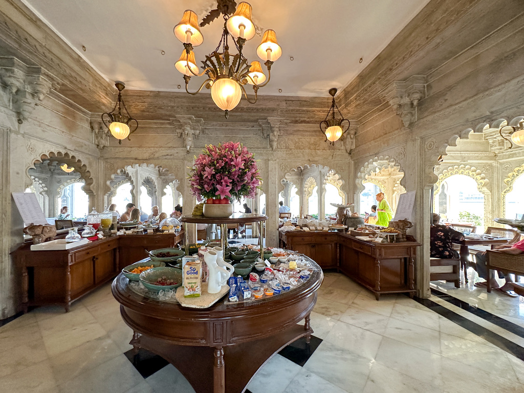a room with a table with food and a group of peopleTaj Lake Palace Review
