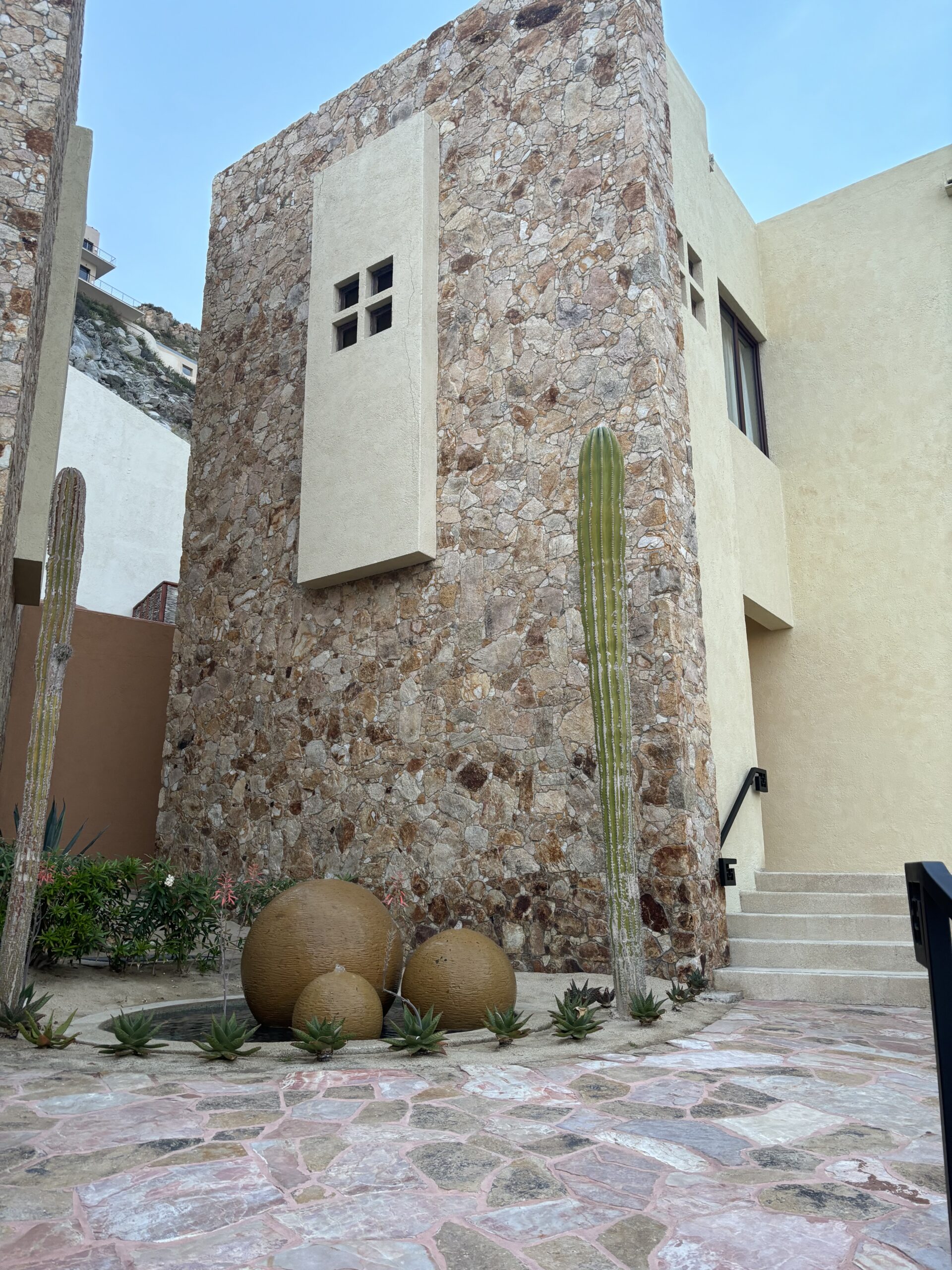 a stone tower with cactus in front of it