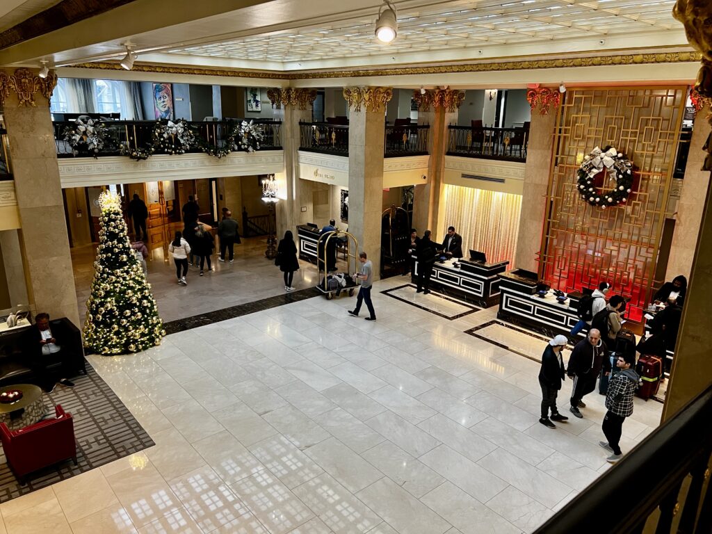 a large lobby with a christmas tree and people walking