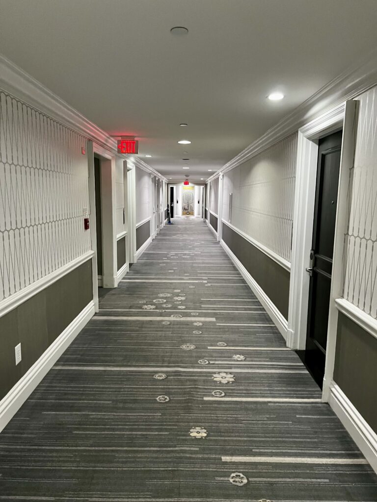 a hallway with a door and exit sign