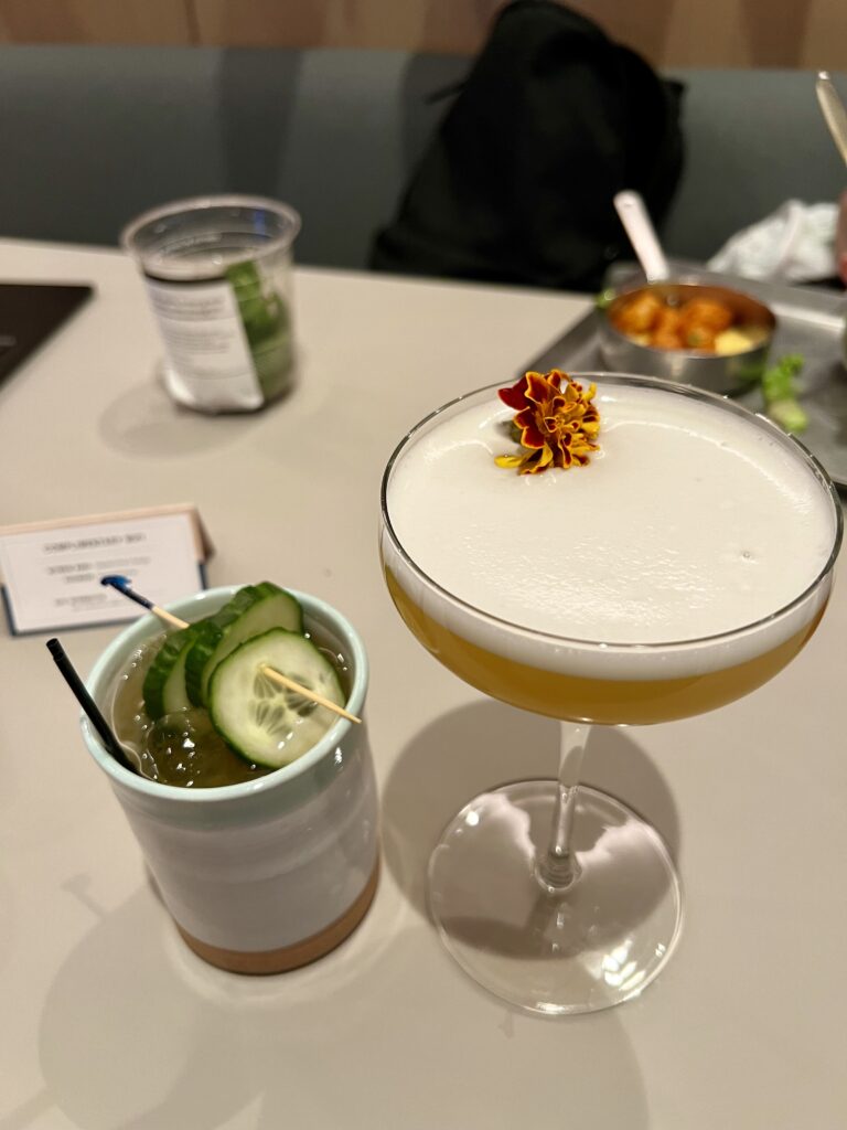 a two glasses of liquid with a flower on top