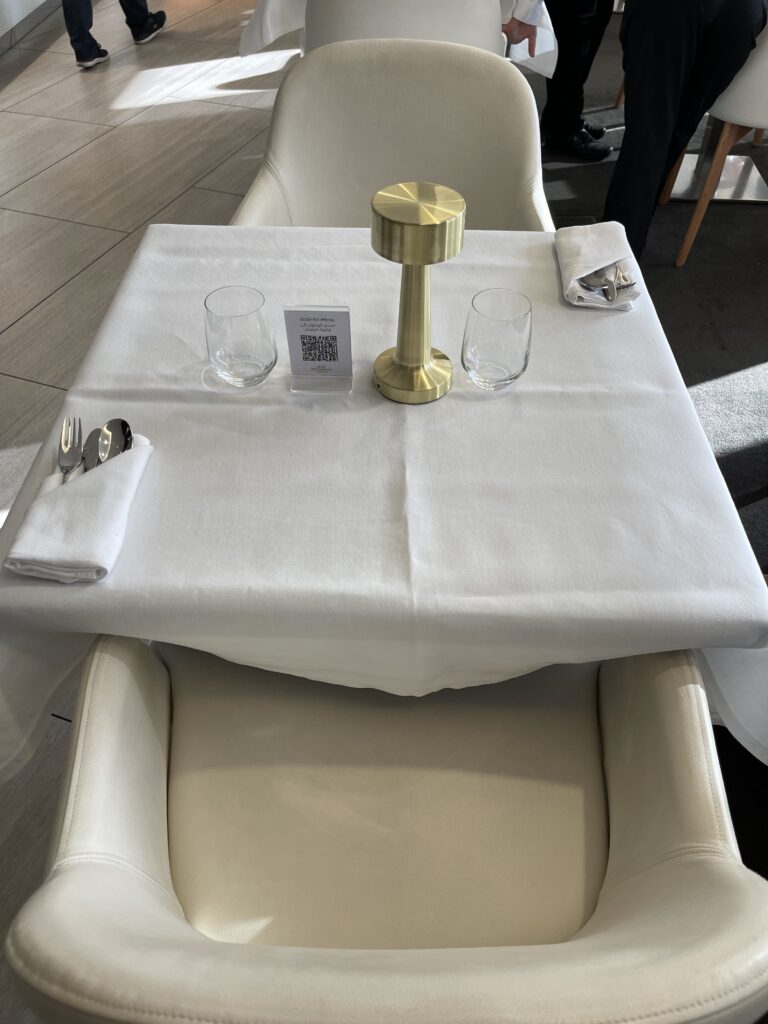 a table with a gold candle holder and glasses on it