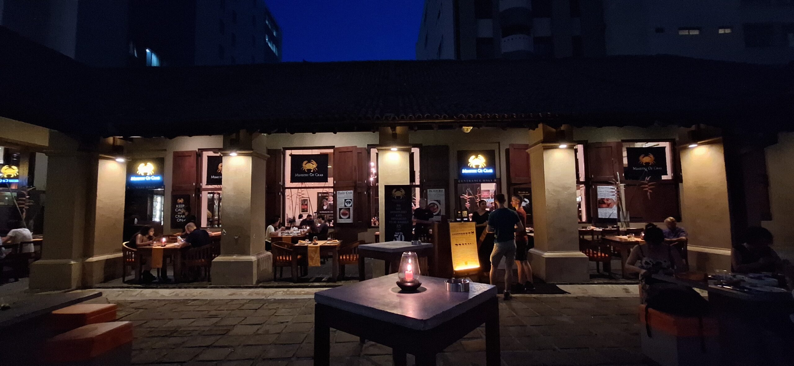 a building with tables and chairs outside at night