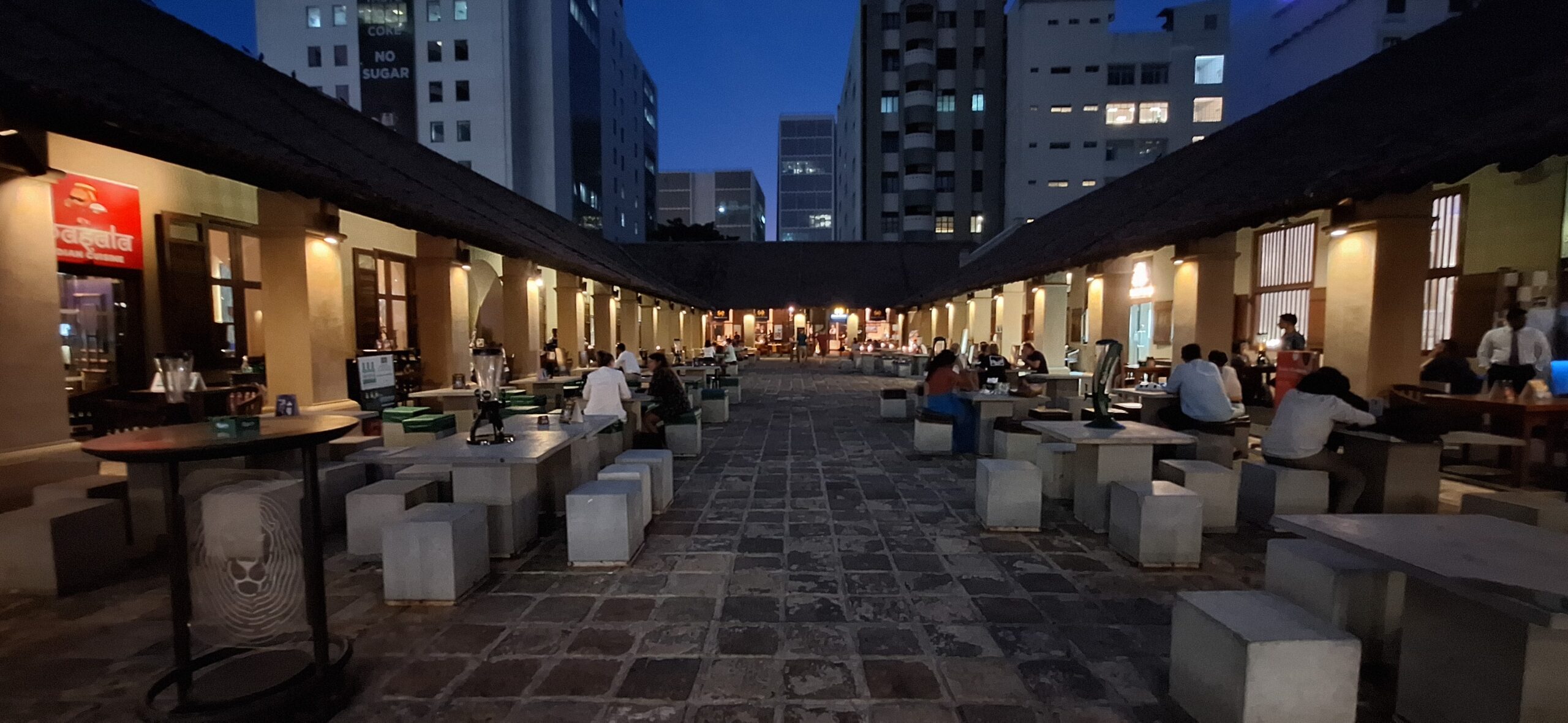 people sitting at tables in a courtyard