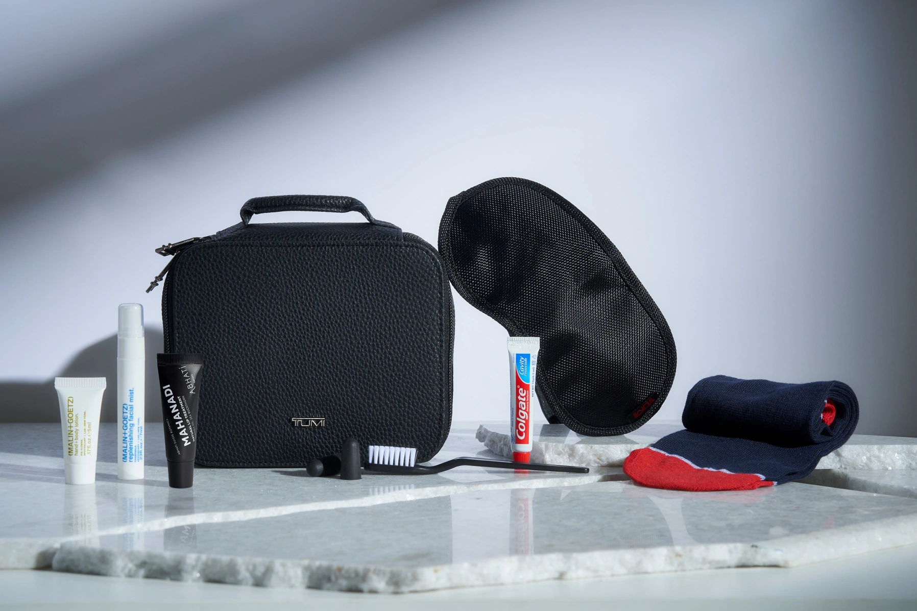 a black bag with a toothbrush and toothpaste on a marble surface