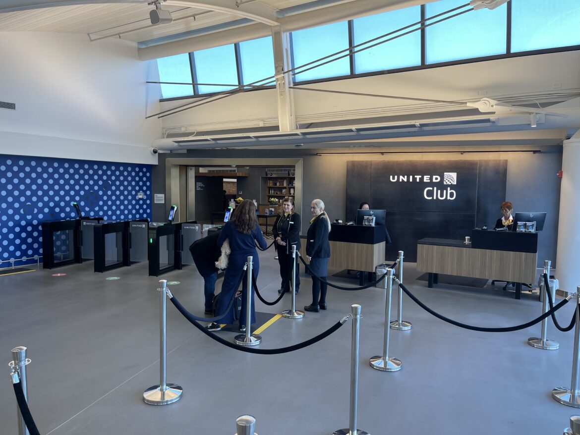 people standing in a line in front of a reception desk