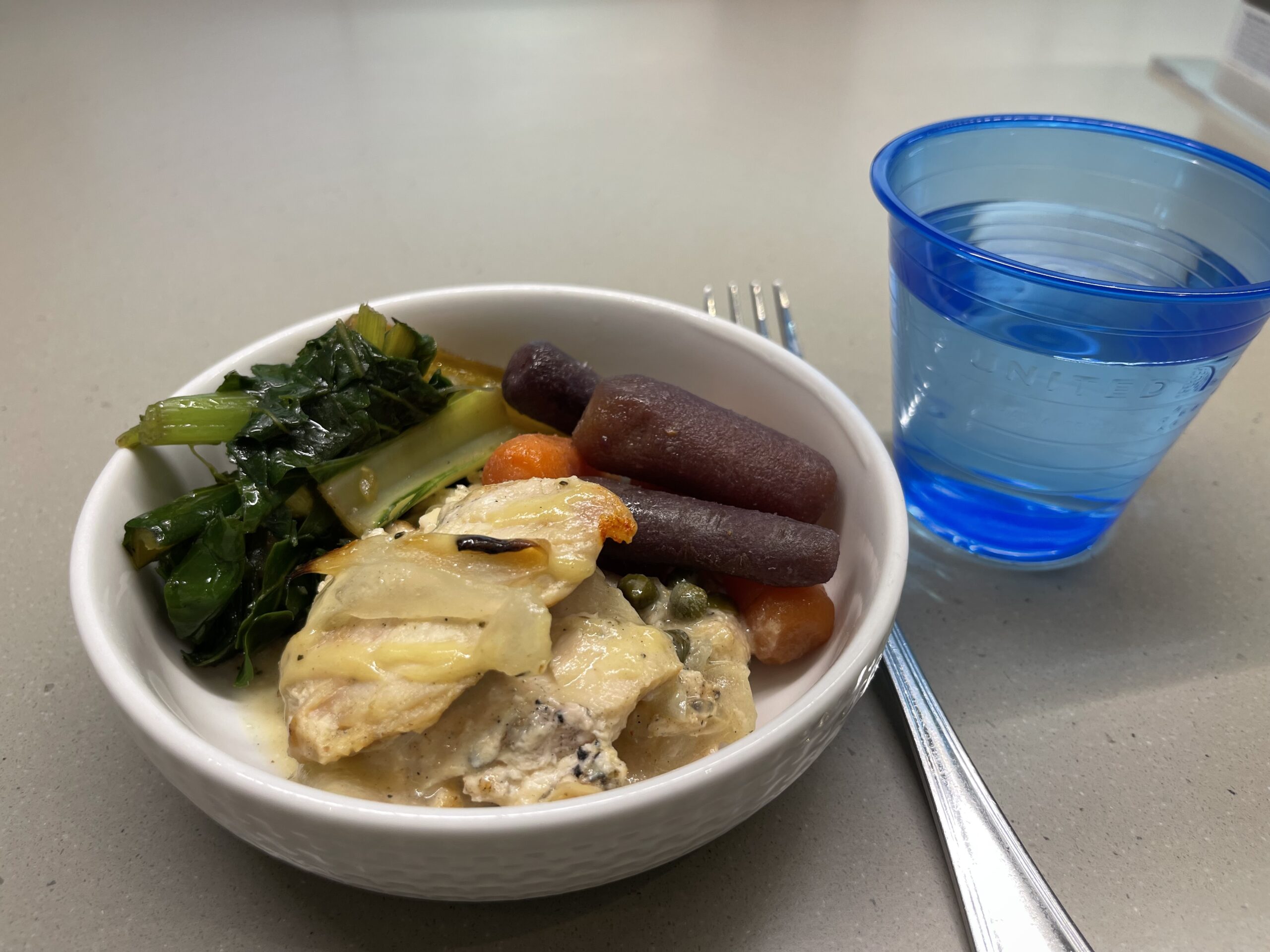 a bowl of food next to a glass of water