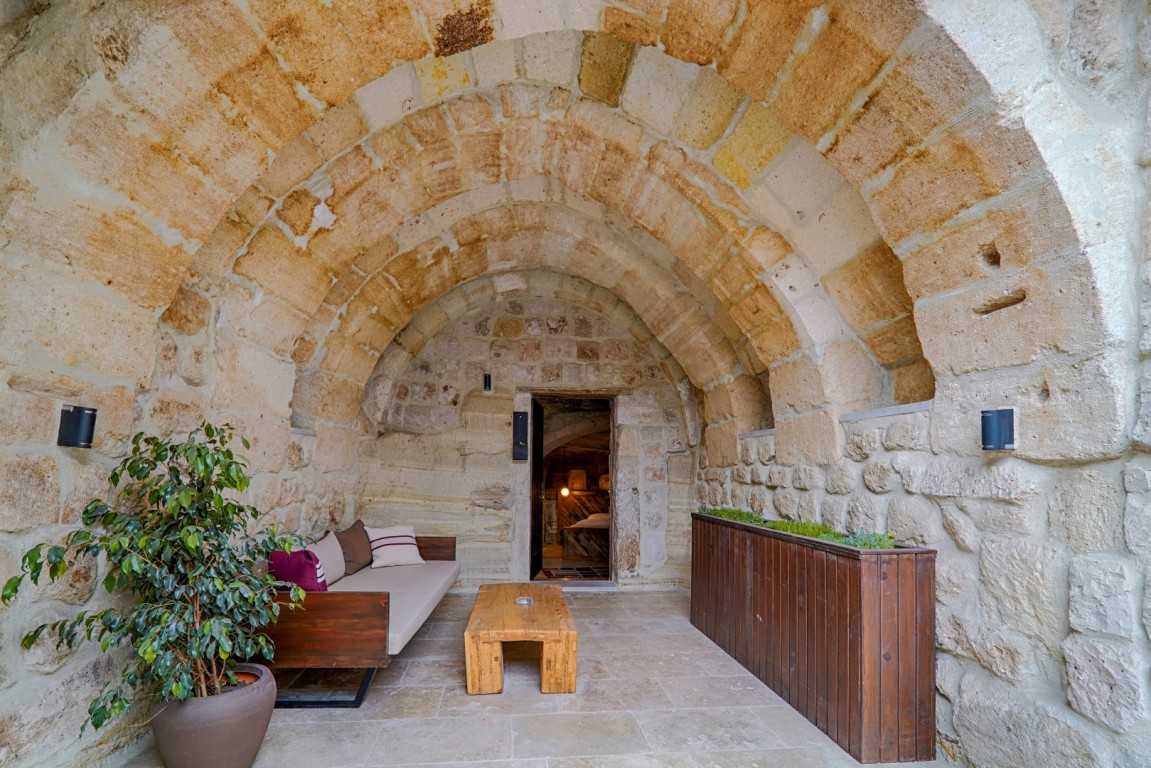 a stone archway with a couch and a coffee table