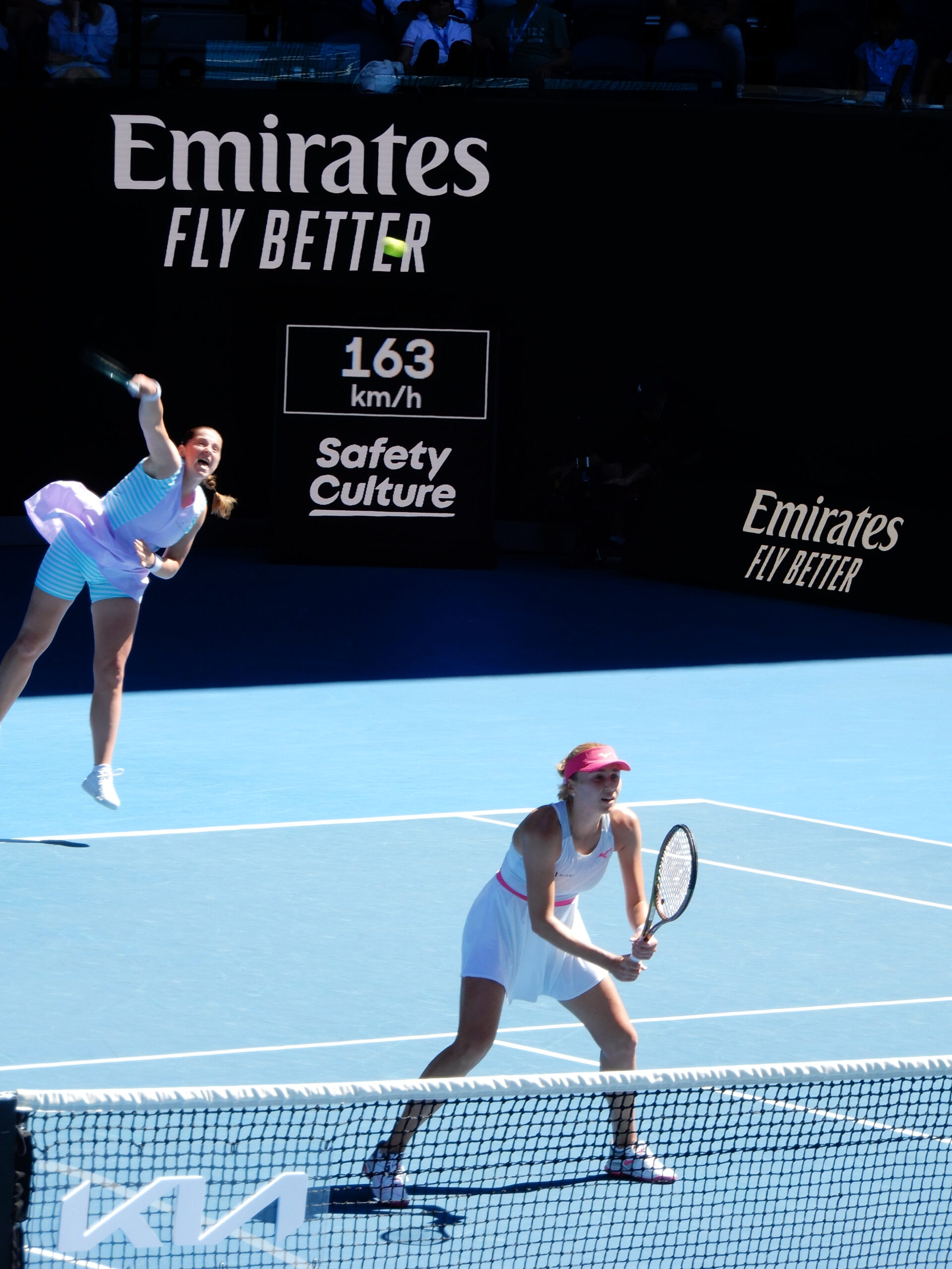 two women playing tennis on a court