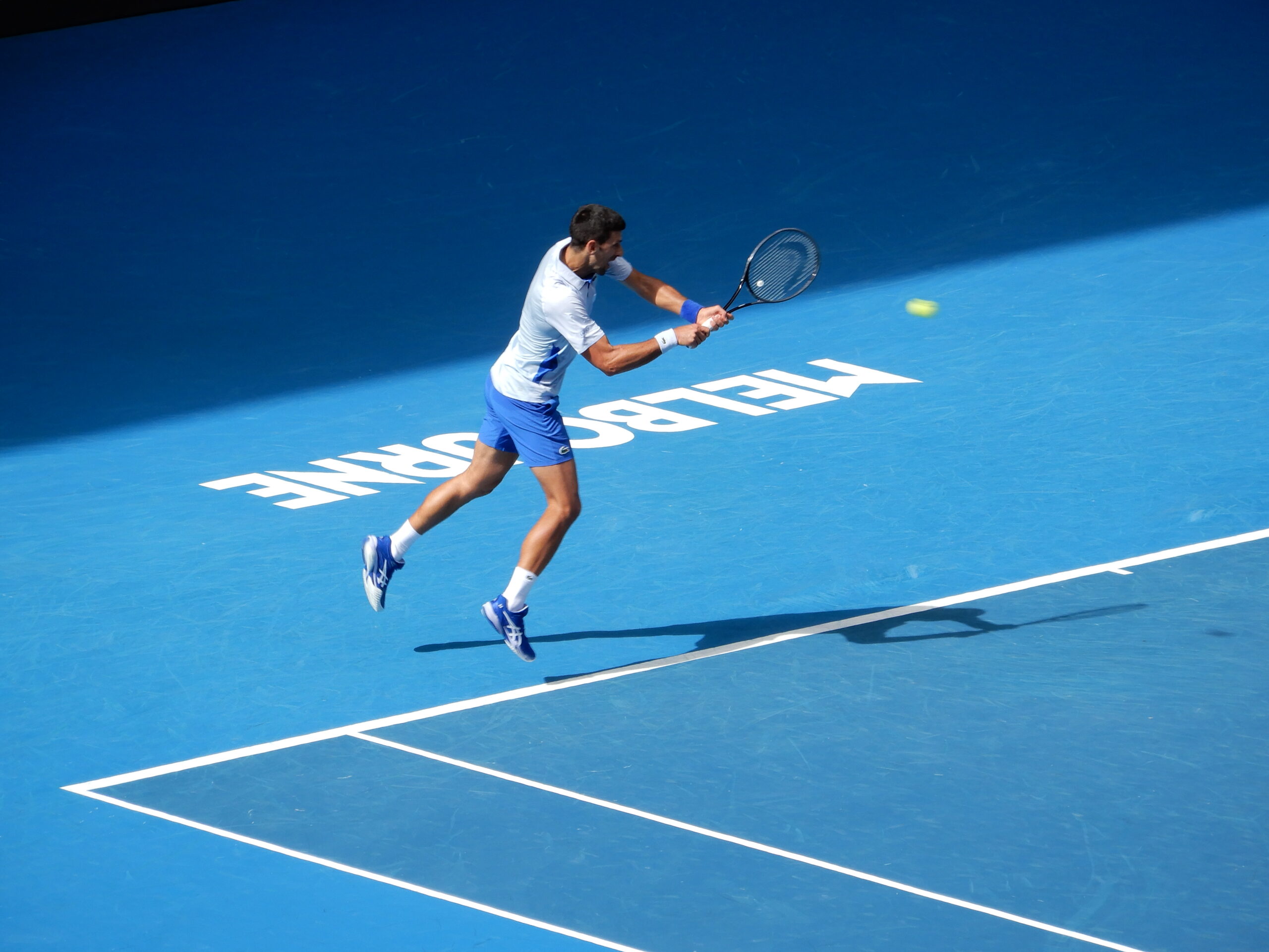 a man playing tennis on a blue court