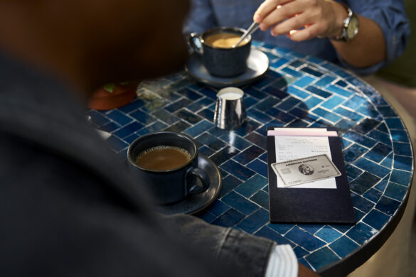 a person sitting at a table with coffee and a notepad