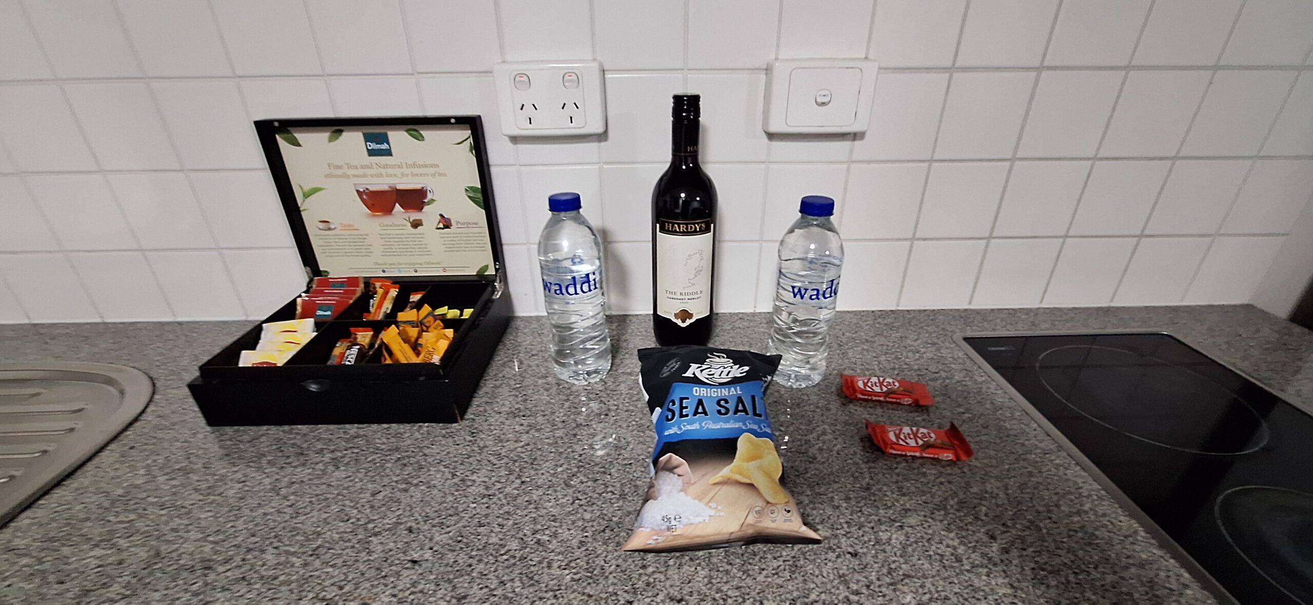 a bottle of wine and snacks on a counter