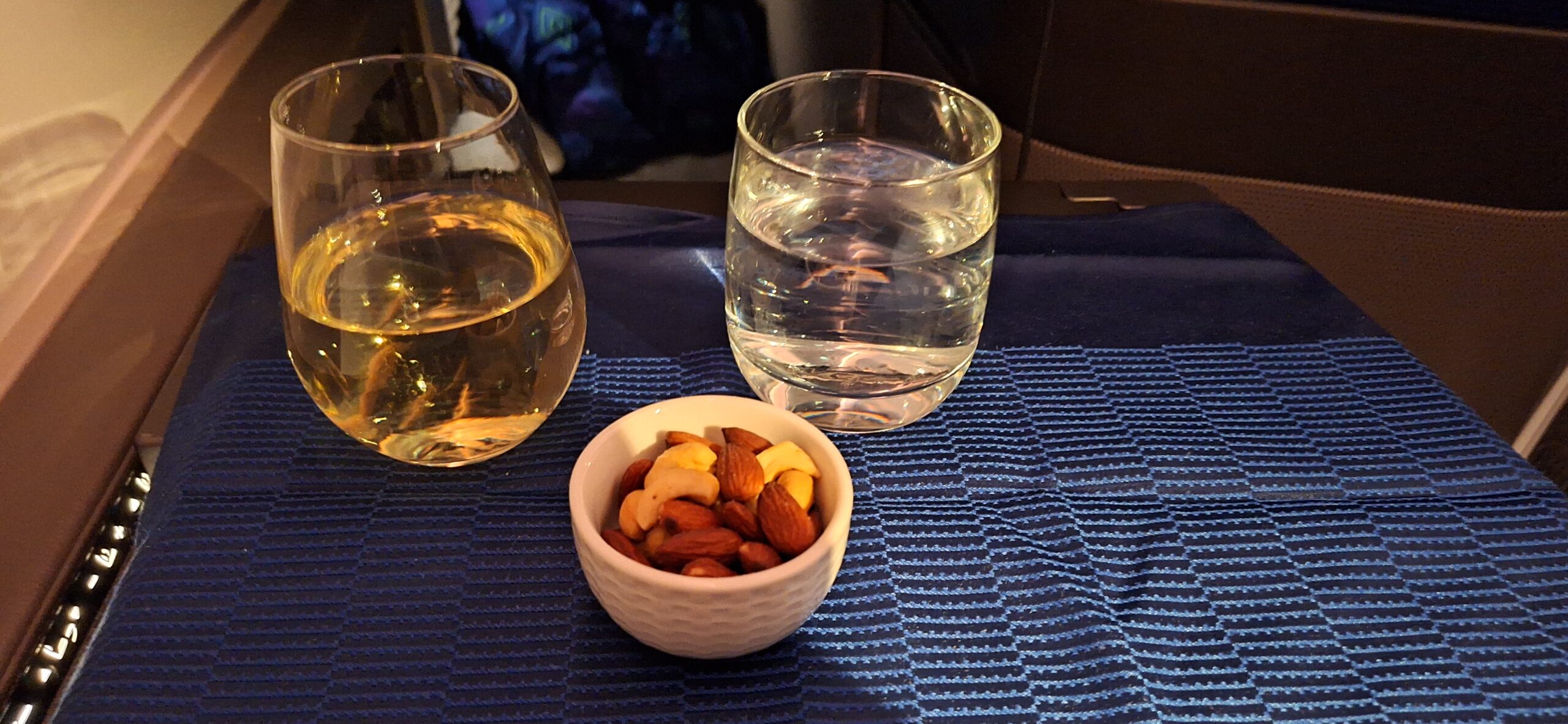 a bowl of nuts and a glass of water