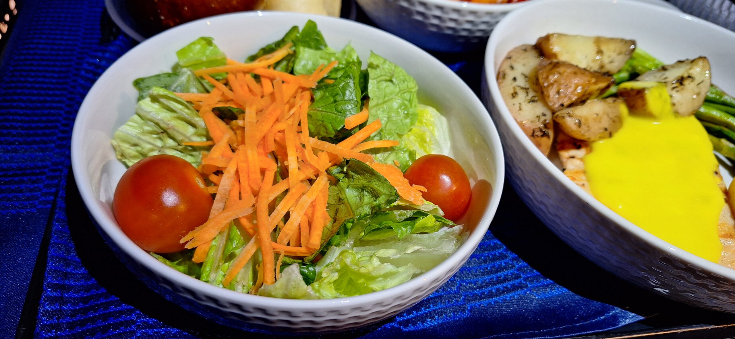 a bowl of salad with carrots and tomatoes