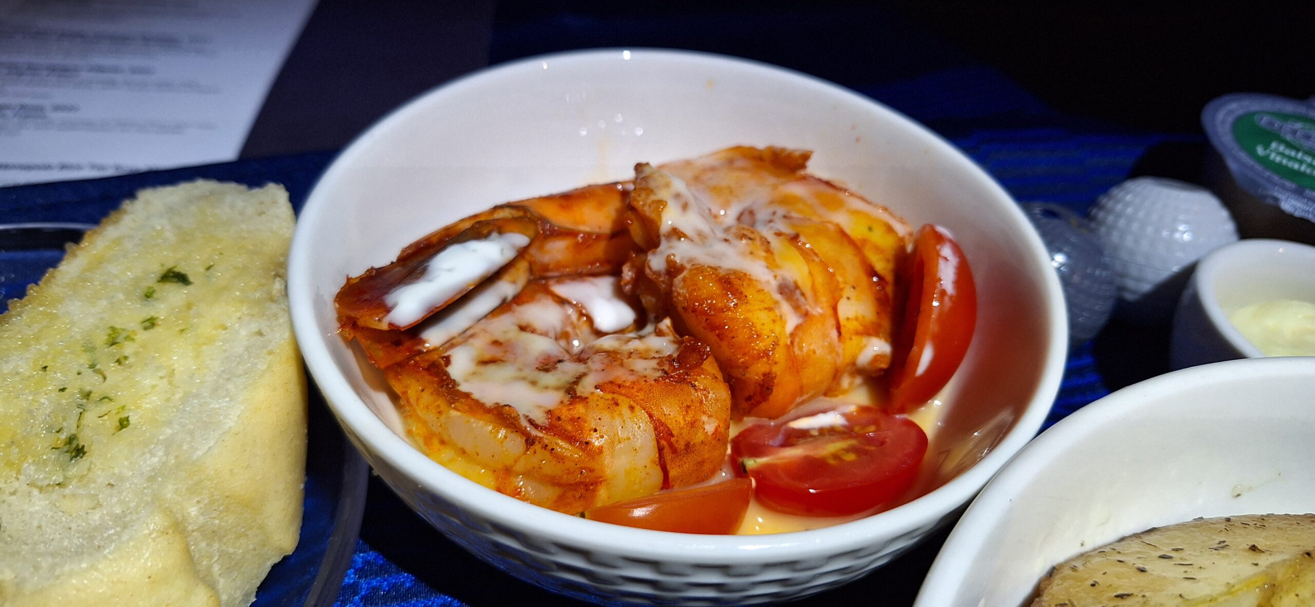 a bowl of shrimp with tomatoes and sauce